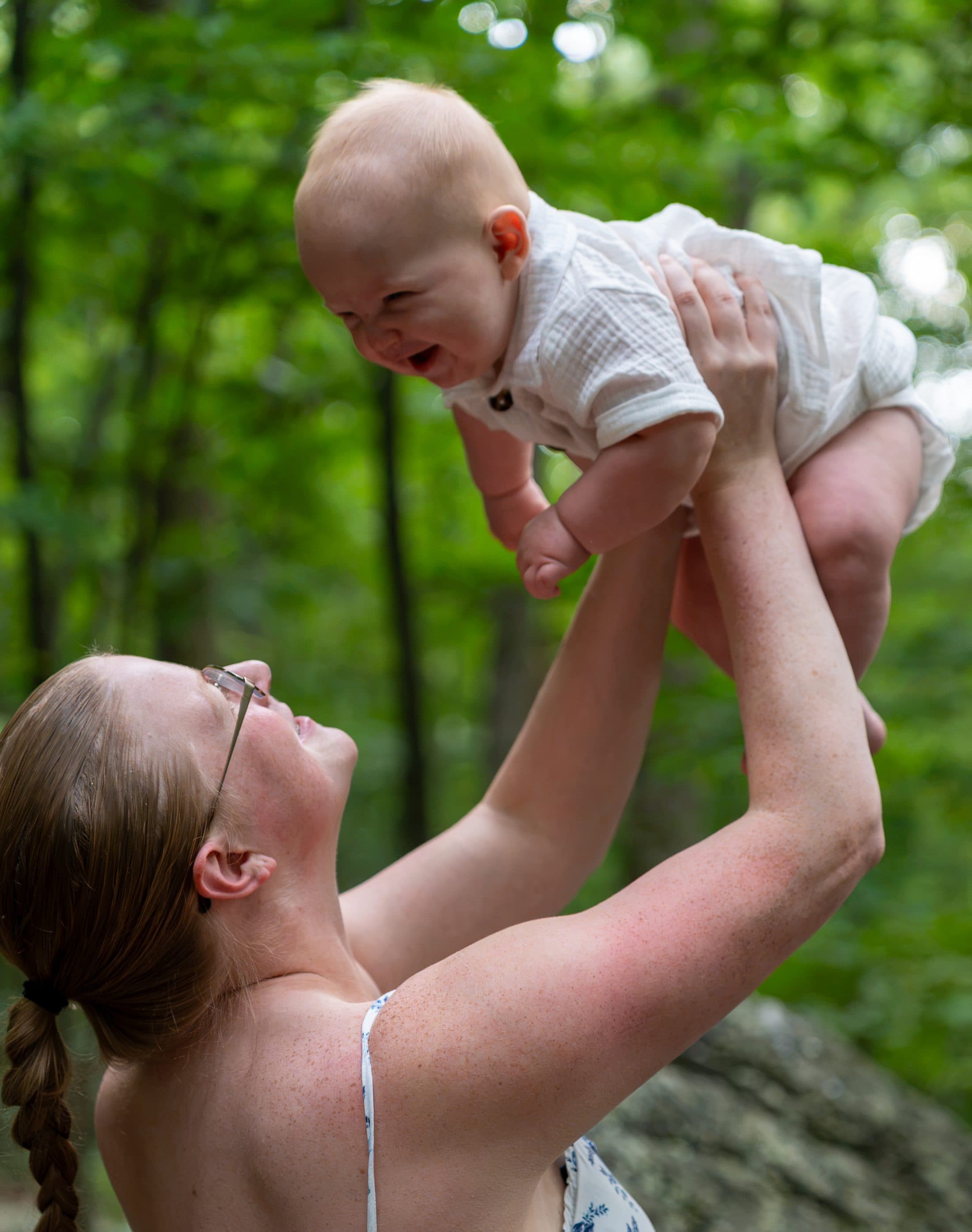 A mother lifting her laughing baby above her head